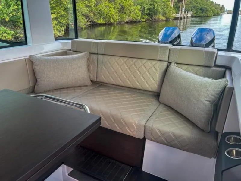 Slide: The Image of Luxurious seating in 2024 Axopar 37XC CROSS CABIN, featuring elegant cushions and scenic water view. - 18
