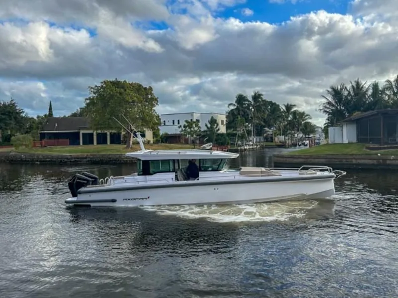 Slide: The Image of 2024 Axopar 37XC CROSS CABIN cruising on a scenic waterway. - 2