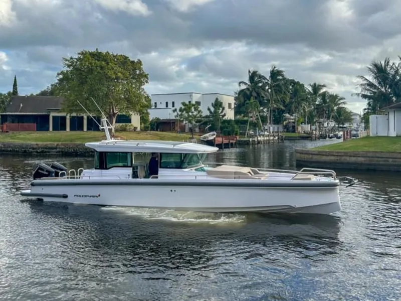 Slide: The Image of 2024 Axopar 37XC CROSS CABIN boat cruising on a calm waterway. - 3