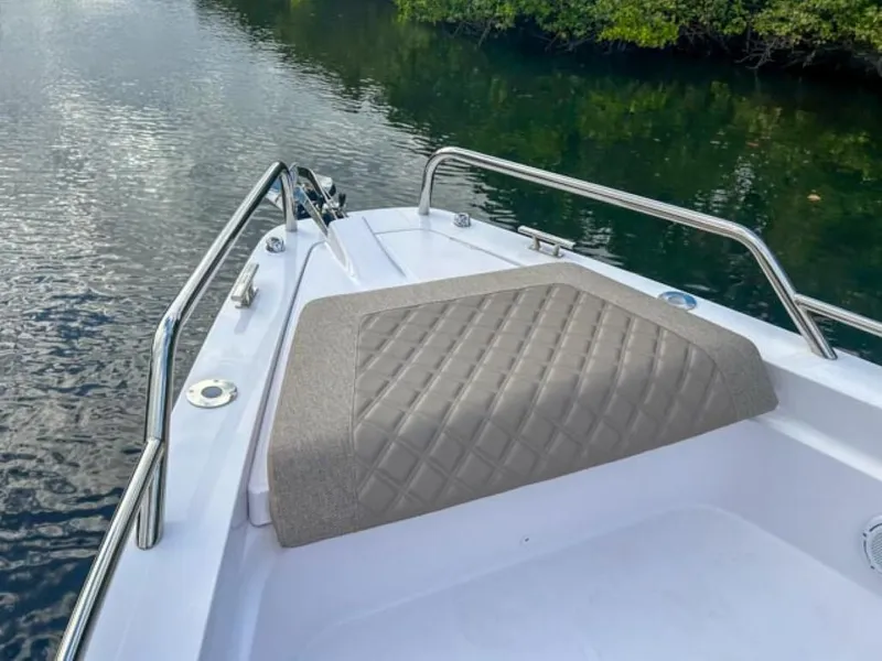 Slide: The Image of 2024 Axopar 37XC CROSS CABIN bow with cushioned seating on calm water. - 8