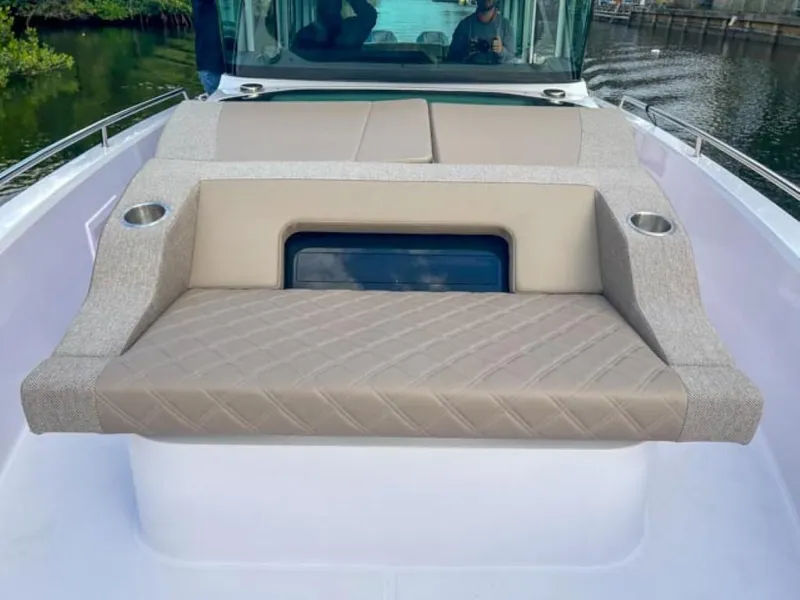 Slide: The Image of 2024 Axopar 37XC CROSS CABIN boat with cushioned seating and cup holders on deck. - 9