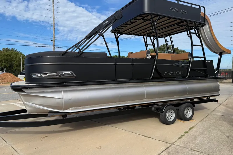 Slide: The Image of 2026 Avalon Catalina Entertainer Funship pontoon boat on trailer, featuring sleek black design. - 5