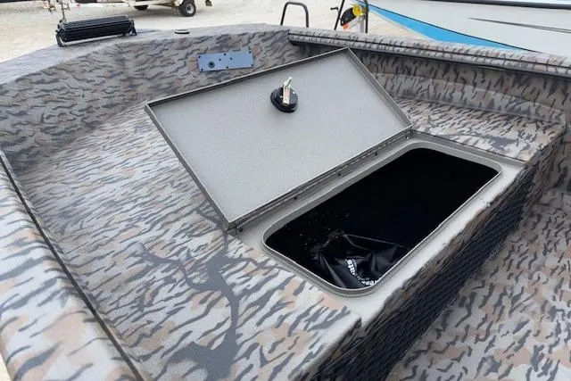 Slide: The Image of 2026 Xpress XTS16 boat with open storage compartment, camo pattern design. - 10