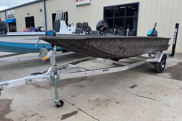 Slide: The Image of 2026 Xpress XTS16 boat on trailer, parked outside a building. - 12