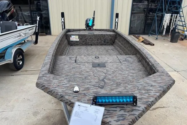 Slide: The Image of 2026 Xpress XTS16 boat with camouflage design and blue LED light bar. - 2