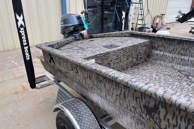 Slide: The Image of 2026 Xpress XTS16 boat with camouflage design on a trailer, featuring an outboard motor. - 3