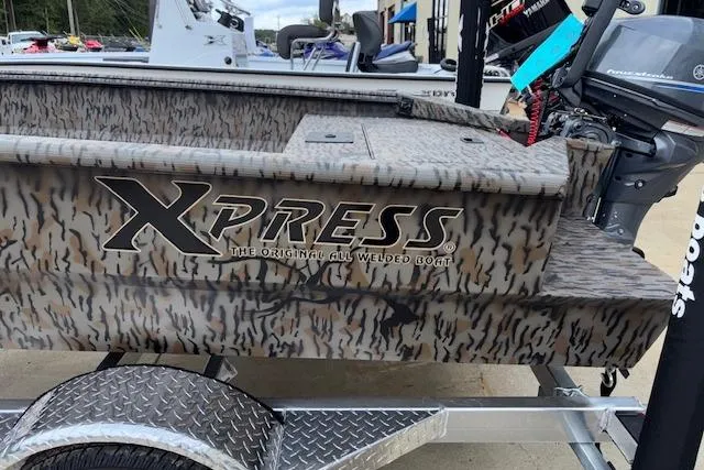 Slide: The Image of 2026 Xpress XTS16 boat with camo design on a trailer, featuring welded construction. - 7