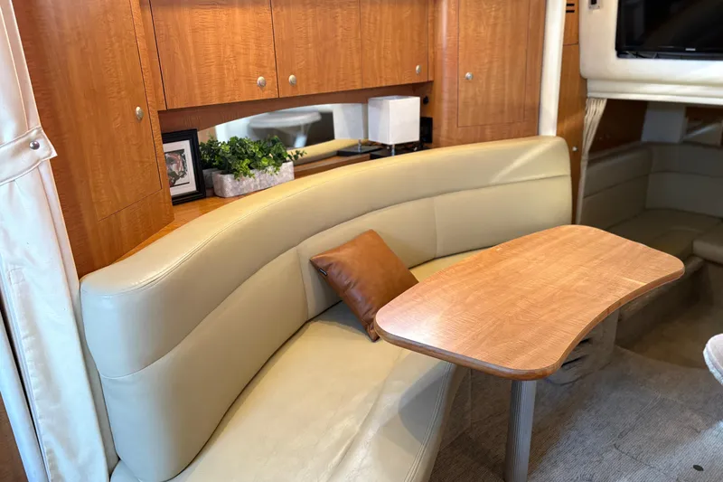 Slide: The Image of Interior of 2006 Sea Ray 320 Sundancer with beige seating and wooden table. - 21