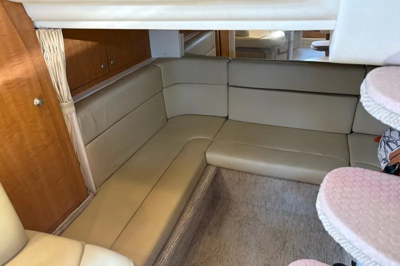 Slide: The Image of Interior of 2006 Sea Ray 320 Sundancer with beige seating and wooden cabinetry. - 23