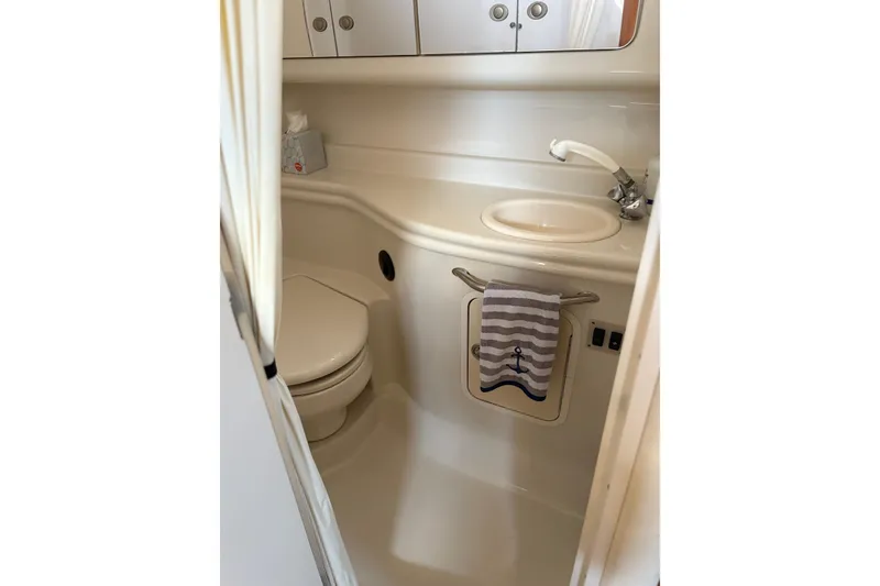 Slide: The Image of Compact bathroom in 2006 Sea Ray 320 Sundancer yacht, featuring sink and toilet. - 24
