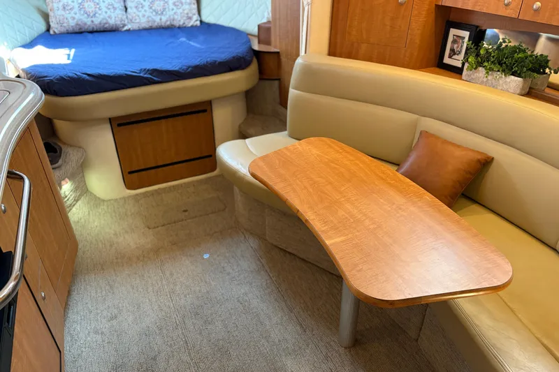 Slide: The Image of Interior of 2006 Sea Ray 320 Sundancer with cozy seating and wooden table. - 25