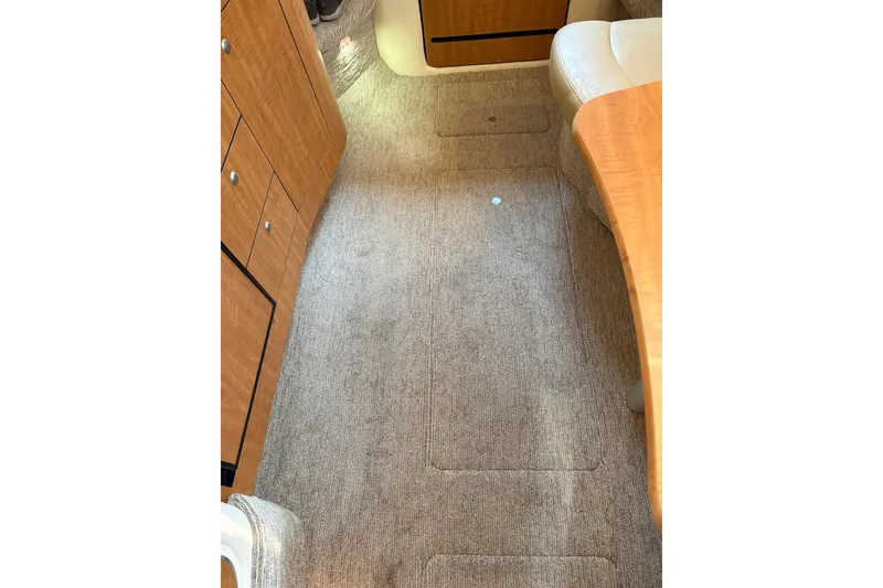 Slide: The Image of Interior of 2006 Sea Ray 320 Sundancer with carpeted flooring and wooden cabinetry. - 26