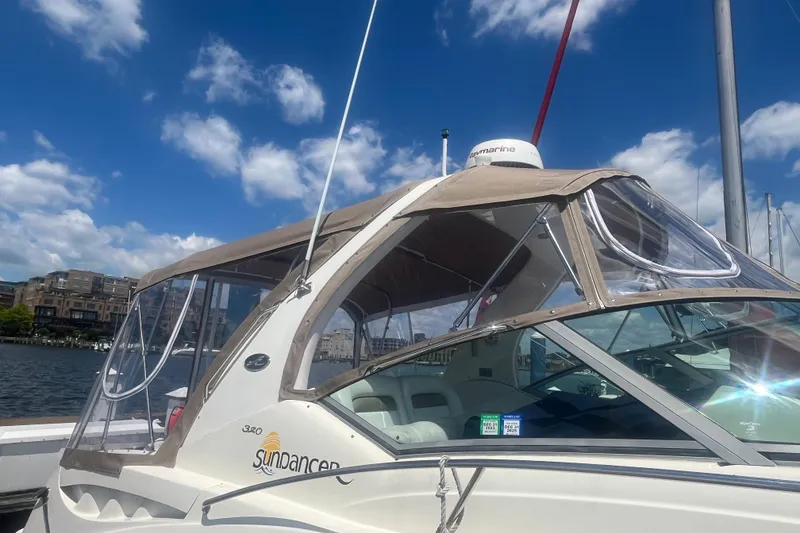 Slide: The Image of 2006 Sea Ray 320 Sundancer boat docked under a clear blue sky. - 3