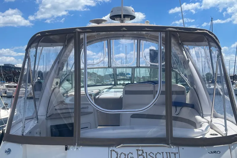 Slide: The Image of 2006 Sea Ray 320 Sundancer boat with clear enclosure, docked at marina under blue sky. - 4