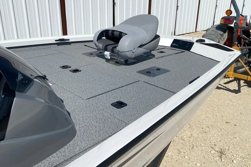 Slide: The Image of 2026 G3 Sportsman 1710PFX boat with gray deck and seating, parked outdoors. - 12