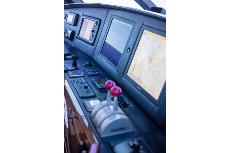 Slide: The Image of Control panel of 2002 Viking 65 Enclosed Bridge yacht with navigation screens and controls. - 38
