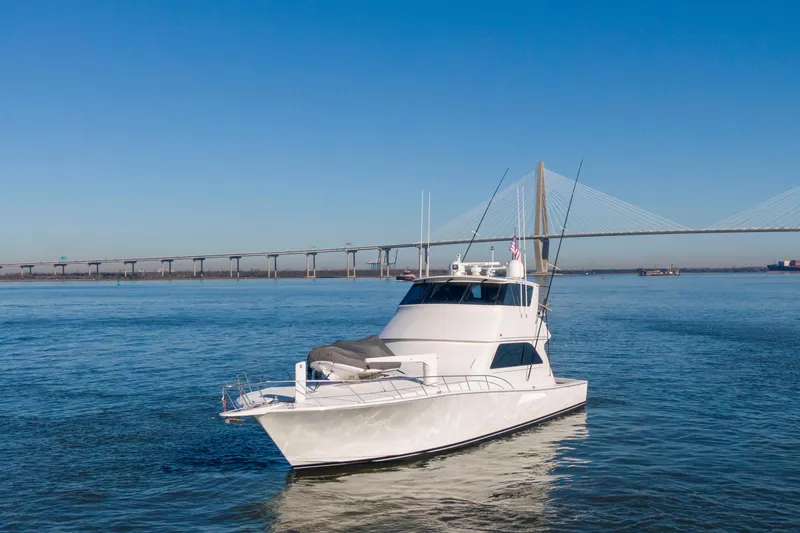 Slide: The Image of 2002 Viking 65 Enclosed Bridge yacht cruising near a large suspension bridge. - 4