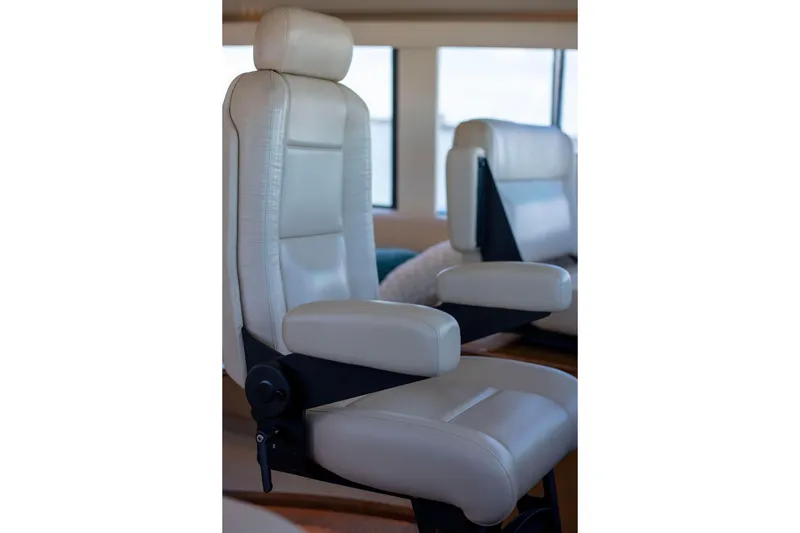 Slide: The Image of Luxurious white leather seating inside a 2002 Viking 65 Enclosed Bridge yacht. - 44