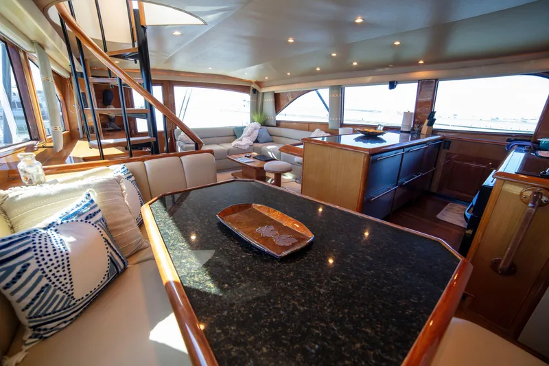 Slide: The Image of Luxurious interior of 2002 Viking 65 Enclosed Bridge yacht with elegant furnishings and spiral staircase. - 64