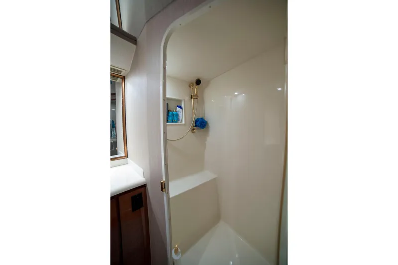 Slide: The Image of Shower area inside 2002 Viking 65 Enclosed Bridge yacht, featuring sleek design and storage shelves. - 73