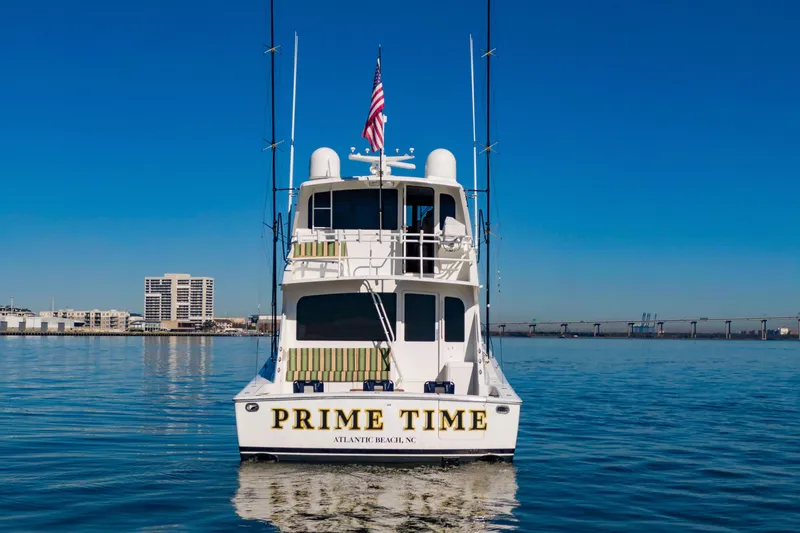 Slide: The Image of 2002 Viking 65 Enclosed Bridge yacht on calm water, cityscape in background. - 8