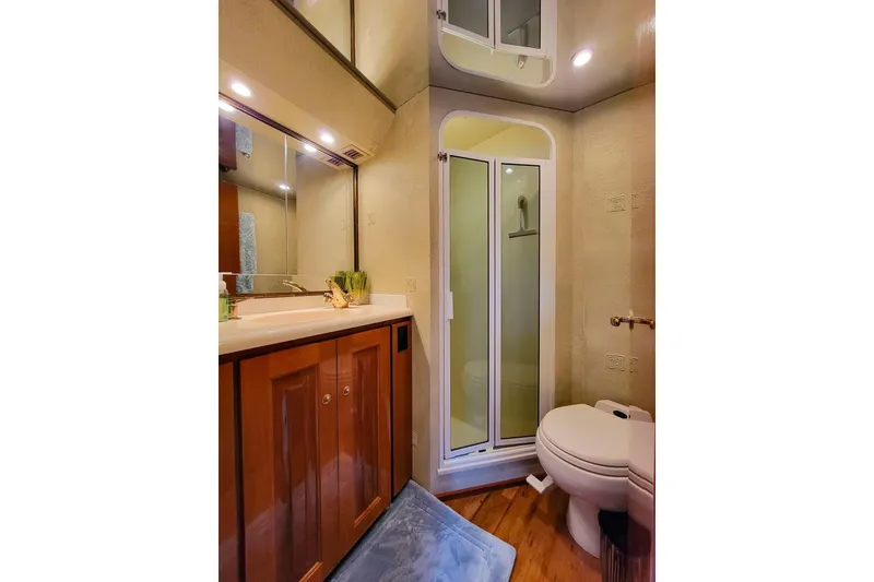 Slide: The Image of Luxurious bathroom in 2002 Viking 65 Enclosed Bridge yacht with shower and wooden cabinetry. - 80