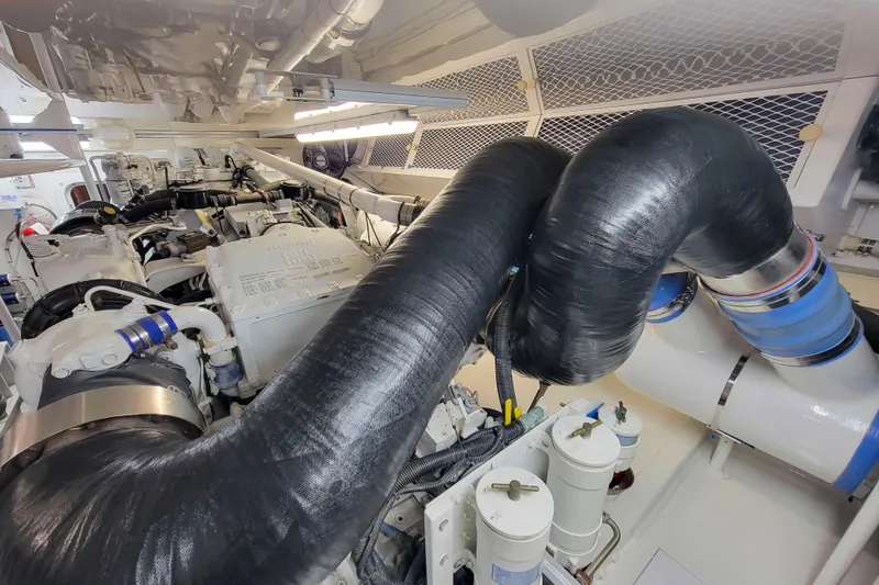 Slide: The Image of Engine room of a 2002 Viking 65 Enclosed Bridge yacht, showcasing complex machinery. - 91