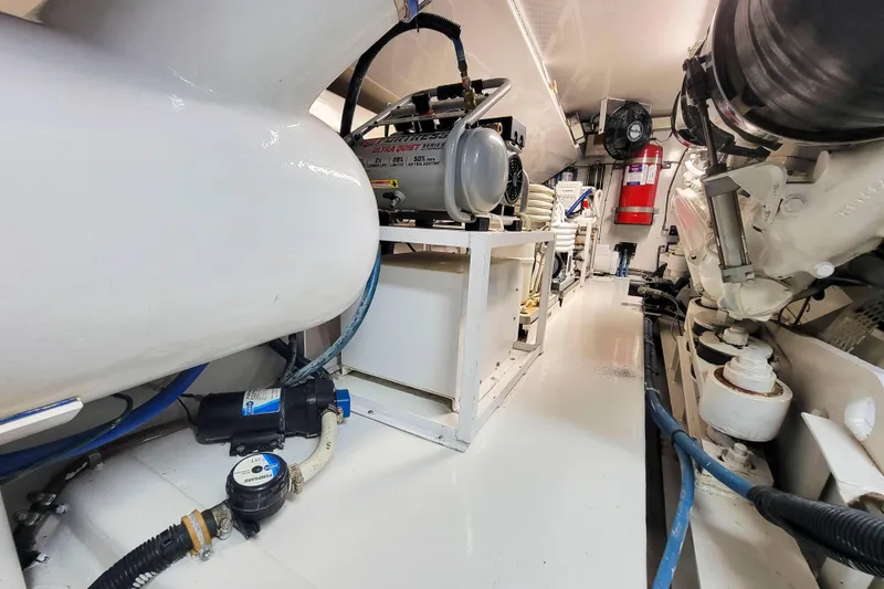 Slide: The Image of Engine room of 2002 Viking 65 Enclosed Bridge yacht, featuring mechanical equipment and piping. - 94