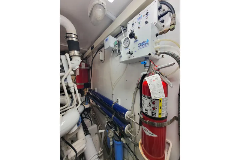Slide: The Image of Engine room of 2002 Viking 65 Enclosed Bridge with fire extinguisher and watermaker system. - 97
