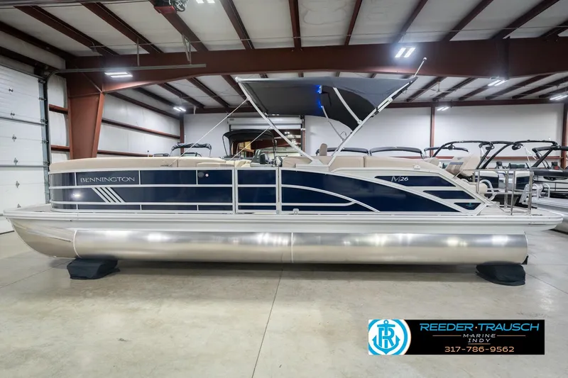 Slide: The Image of 2026 Bennington 26 MSL pontoon boat in showroom, featuring sleek design and modern amenities. - 11