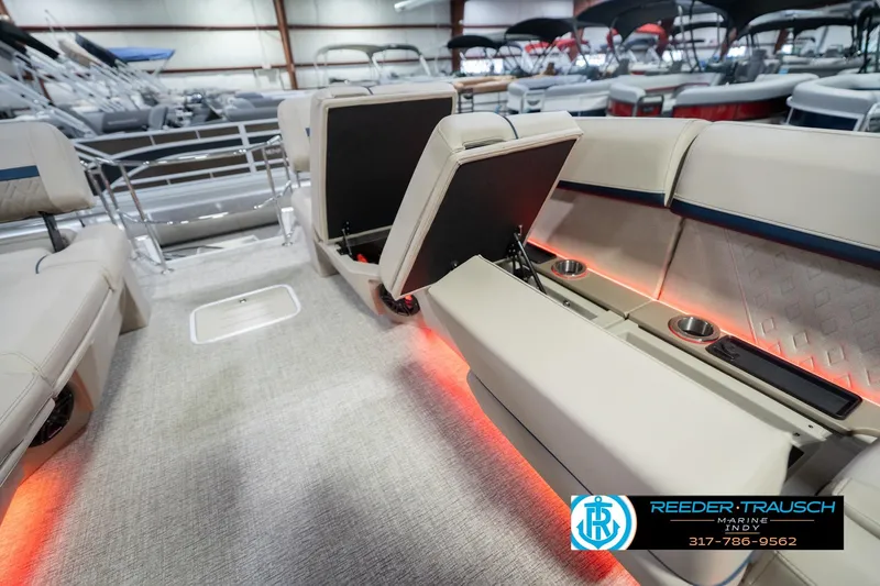 Slide: The Image of 2026 Bennington 26 MSL boat interior with illuminated seating and cup holders in showroom. - 34