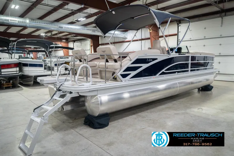 Slide: The Image of 2026 Bennington 26 MSL pontoon boat in showroom with canopy and ladder. - 8