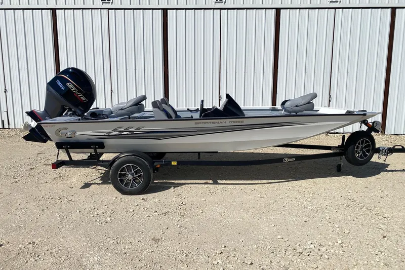 The Image of 2026 G3 Sportsman 1710SE fishing boat on trailer, parked outdoors. - 0