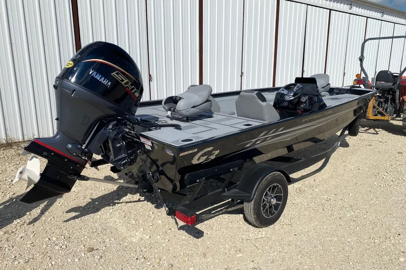 Slide: The Image of 2026 G3 Sportsman 1710SE boat with Yamaha engine, parked on gravel near a metal building. - 5