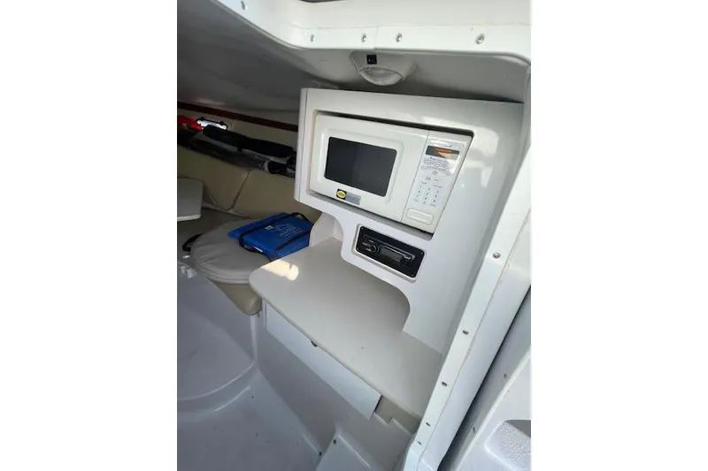 Slide: The Image of Interior of 2001 Four Winns 285 Sundowner boat with microwave and seating area. - 3