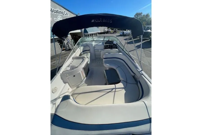Slide: The Image of 2001 Four Winns 285 Sundowner boat interior with seating and canopy, docked outdoors. - 8