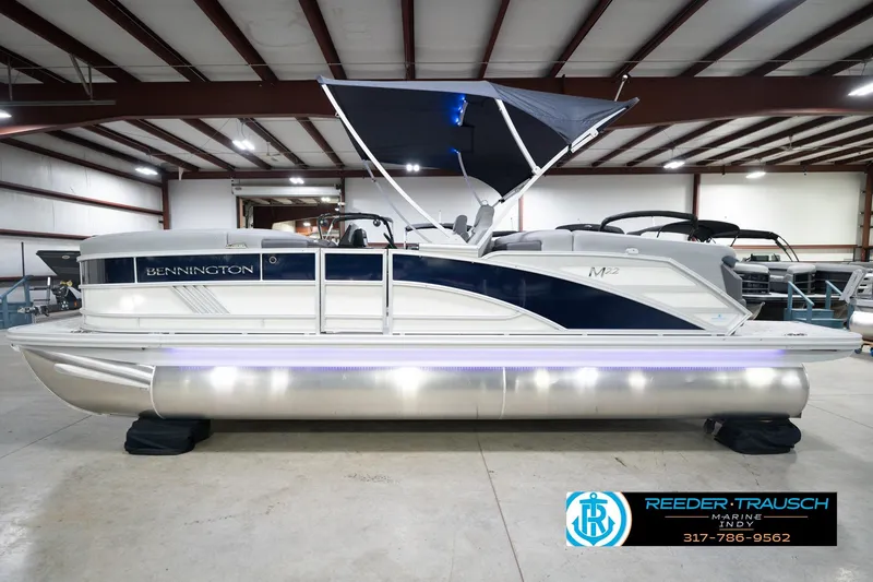 Slide: The Image of 2026 Bennington 22 MFB pontoon boat in showroom with canopy and LED lights. - 11