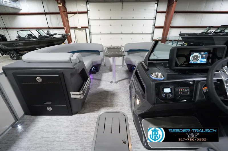 Slide: The Image of 2026 Bennington 22 MFB boat interior with modern dashboard and seating in a showroom. - 20