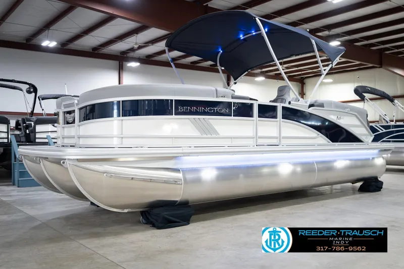 Slide: The Image of 2026 Bennington 22 MFB pontoon boat in showroom with canopy and sleek design. - 4