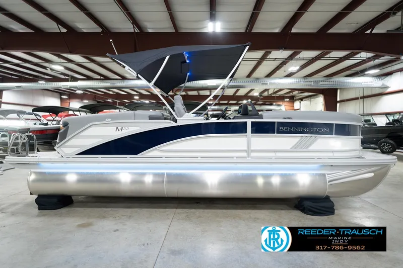 Slide: The Image of 2026 Bennington 22 MFB pontoon boat in showroom with canopy and sleek design. - 7