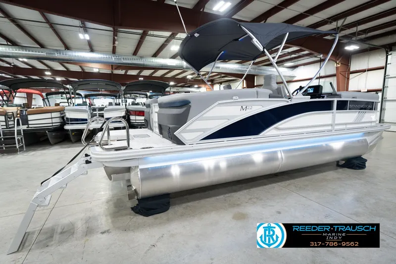 Slide: The Image of 2026 Bennington 22 MFB pontoon boat displayed indoors at Reeder-Trausch Marine showroom. - 8