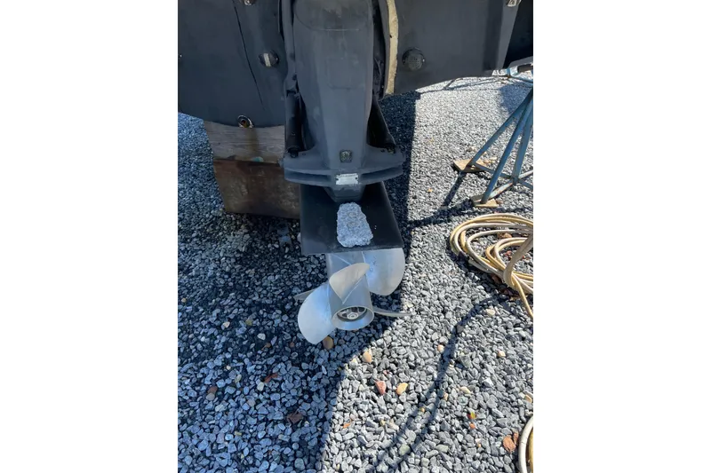 Slide: The Image of 2007 Chaparral 330 Signature boat propeller on gravel surface, with coiled rope nearby. - 40