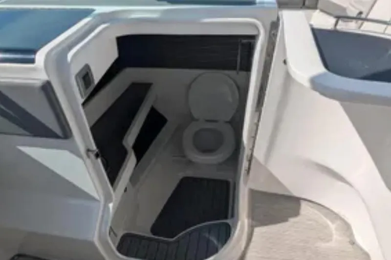 Slide: The Image of 2021 Sea Ray 310 SLX boat interior with compact bathroom and toilet. - 22
