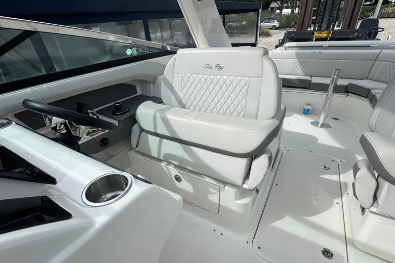 Slide: The Image of Interior of a 2021 Sea Ray 310 SLX boat with luxurious seating and steering area. - 25