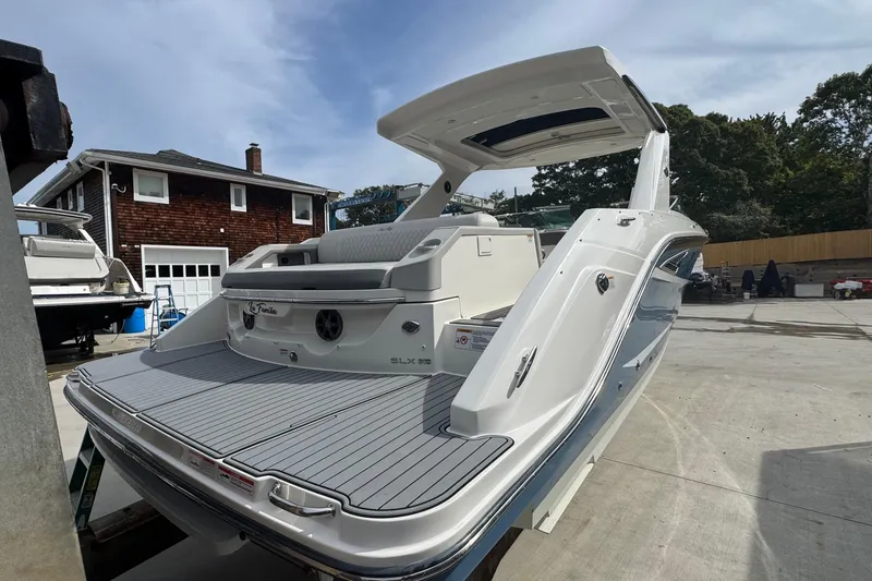Slide: The Image of 2021 Sea Ray 310 SLX boat with sleek design, docked near a house. - 3