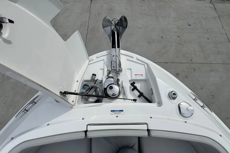 Slide: The Image of 2021 Sea Ray 310 SLX boat anchor compartment with open hatch and equipment. - 31