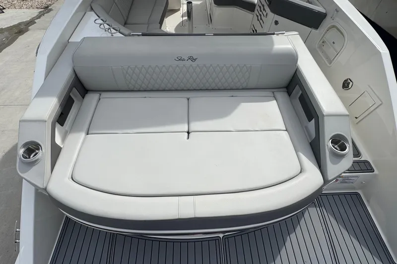 Slide: The Image of 2021 Sea Ray 310 SLX boat interior with cushioned seating and cup holders. - 5