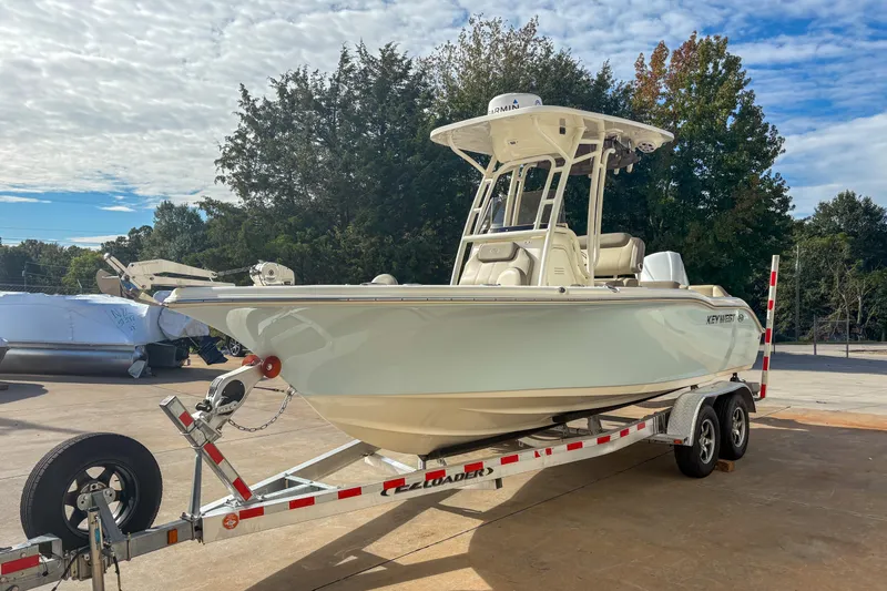 Slide: The Image of 2021 Key West 219 FS boat on trailer, parked outdoors under a partly cloudy sky. - 5