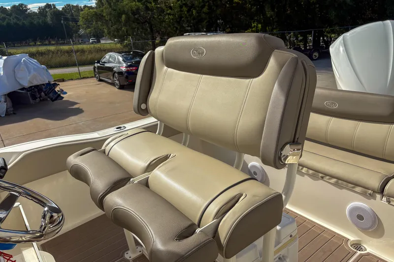 Slide: The Image of 2021 Key West 219 FS boat interior with beige cushioned seating and steering wheel. - 8