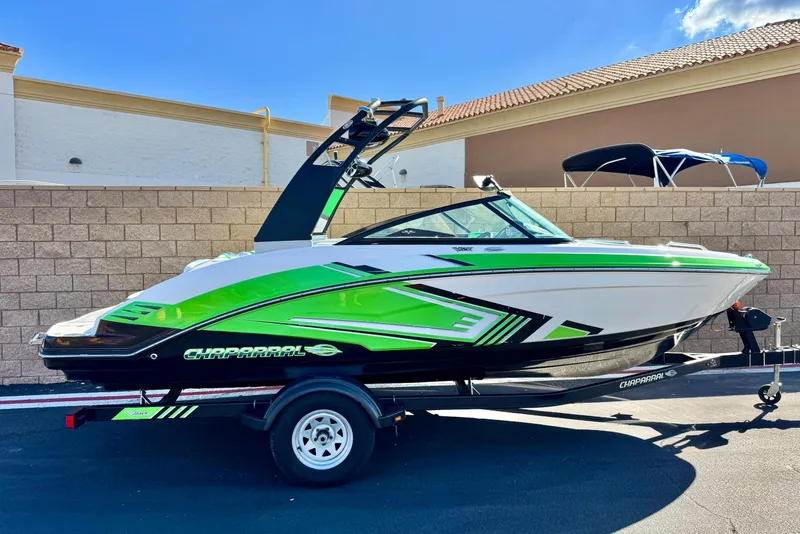 The Image of 2015 Chaparral Vortex 203 VRX boat with vibrant green accents on a trailer. - 0